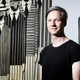 John Cameron Mitchell poses in front of an artwork by Gaetis during a photo session in the ARP studios in Paris on June 13, 2018